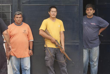 Propietarios de una tienda permanecen en su ingreso armados para impedir la posible acción de saqueadores en San Miguel de Tucumán.
AP / JULIO PANTOJA