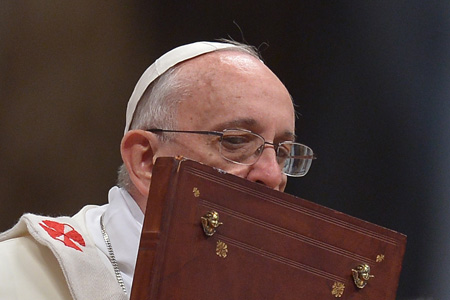 El papa Francisco besa el libro de los evangelios durante una misa en la basílica de San Pedro, en Ciudad del Vaticano, el 1 de enero de 2014.AFP / FILIPPO MONTEFORTE