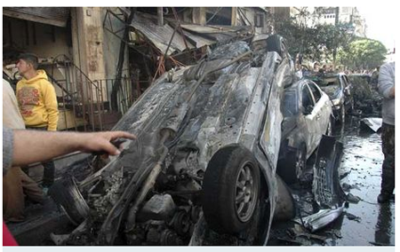 Varios sirios observan los restos del atentado de los dos coches bomba que estallarON en la calle al-Khodhary, en el vecindario de Karm al-Loz, en Homs