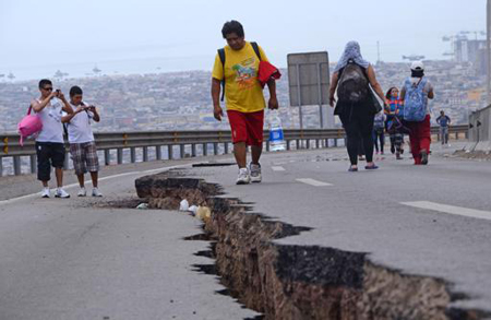 Varias personas observan la grieta en una carretera en Iquique, al norte de Chile, provocada por un terremoto y sus réplicas que sacudieron el país el 2 y 3 de abril de 2014
