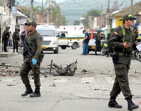 Foto de archivo donde policías colombianos inspeccionan la calle donde explotó una moto bomba, cerca de un edificio gubernamental en Pradera, en hecho atribuido a las FARC.