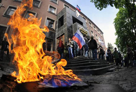 Manifestantes pro rusos queman símbolos ucranianos frente al edificio administrativo regional después de un enfrentamiento con la policía en Donetsk
AP / EVGEIY MALOLETKA