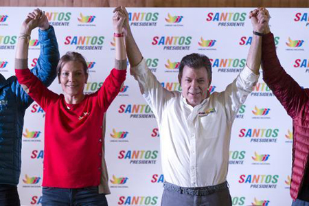 El presidente y candidato a la reelección Juan Manuel Santos y su esposa María Clemencia Rodríguez alzan sus manos durante un acto de cierre de campaña en Bogotá.
AFP