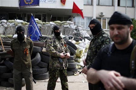 Rebeldes prorrusos armados hacen guardia a las afueras del ayuntamiento en Mariupol, en el este de Ucrania, el 4 de mayo, 2014.