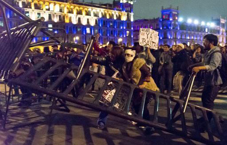 Manifestantes derriban barricadas frente al Palacio Nacional en el Zócalo, en protesta por el anuncio de que los 43 estudiantes desaparecidos fueron masacrados.AFP / OMAR TORRES