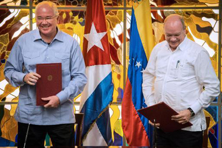 El canciller venezolano, Rafael Ramírez, y el ministro cubano de Comercio Exterior e Inversiones, Rodrigo Malmierca (D), dirman acuerdos de cooperación antes de la cumbre del ALBA.AFP / ADALBERTO ROQUE
