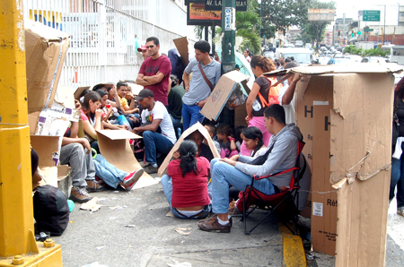 Las personas frente al Daka de Los Cortijos tienen que sentarse, dormir y resguardarse del sol con cajas y cartones