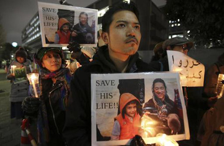 En esta imagen de archivo, tomada el 30 de enero de 2015, manifestates sostienen carteles con la foto del periodista japonés Kenji Goto.AFP / KOJI SASAHARA