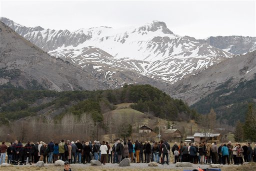 Vecinos rinden homenaje a las víctimas ante un hito erigido como monumento cerca del lugar donde se estrelló ell avión de Germanwings en los Alpes franceses en Le Vernet, Francia, el 28 de marzo de 2015. (AP Foto/Claude Paris)