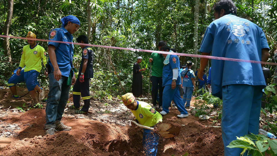 Rescue workers dig a grave containing human remains about one kilometre from the hillside site where shallow graves containing 26 bodies were found on May 1, near the town of Padang Besar in the southern Thai province of Songkhla on May 6, 2015.  Thai police investigating people-smuggling said six more bodies were found on May 6 in the same patch of jungle bordering Malaysia where the remains of dozens of migrants were exhumed last week.   AFP PHOTO        (Photo credit should read STR/AFP/Getty Images)