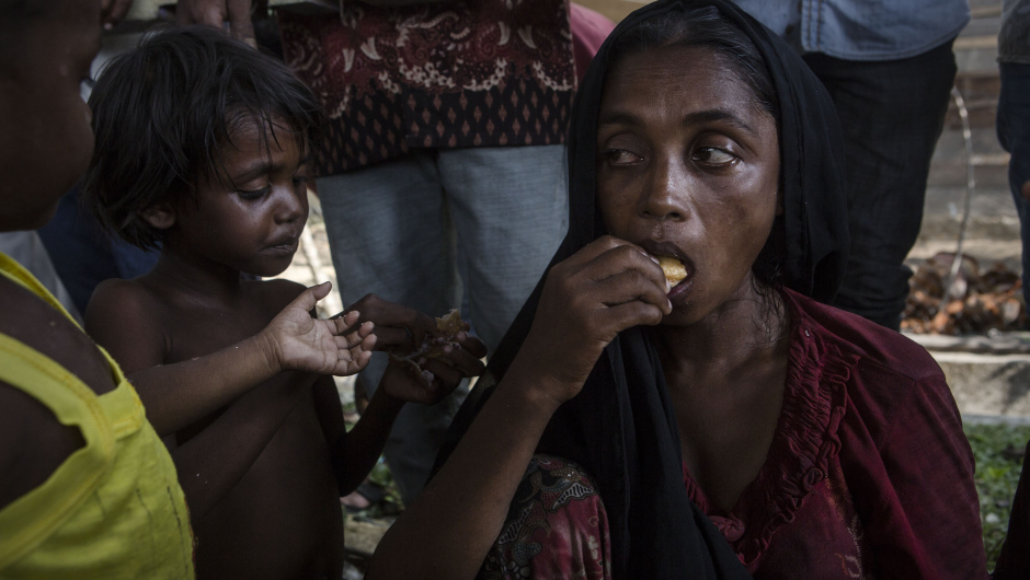 KUTA BINJE, INDONESIA - MAY 20: A Rohingya woman and her children eat after arriving at the port in Julok village on May 20, 2015 in Kuta Binje, Aceh Province, Indonesia. Hundreds of Myanmar's Rohingya refugees have arrived in Indonesia, many requiring medical attention. Thousands more are believed to still be stranded at sea reportedly with no country in the region willing to take them in. Myanmar's Rohingya Muslim community have long been persecuted and marginalized by Myanmar's mostly Buddhist population. (Photo by Ulet Ifansasti/Getty Images)