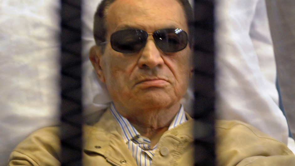 Ousted Egyptian president Hosni Mubarak sits inside a cage in a courtroom during his verdict hearing in Cairo on June 2, 2012. A judge sentenced Mubarak to life in prison after convicting him of involvement in the murder of protesters during the uprising that ousted him last year. AFP PHOTO/STR        (Photo credit should read STR/AFP/GettyImages)