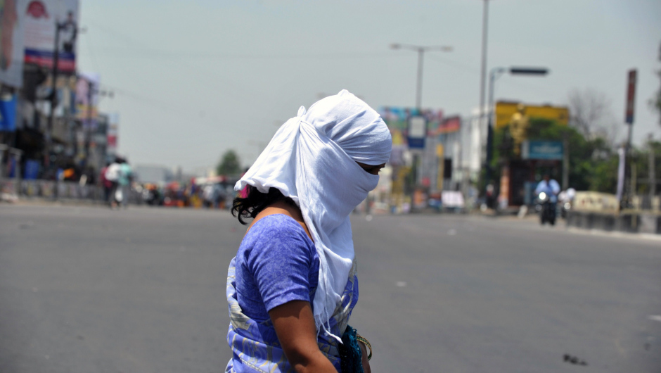 An Indian woman with her face covered crosses the road on the outskirts of Hyderabad on May 25, 2015.  More than 430 people have died in two Indian states from a days-long heatwave that has seen temperatures nudging 50 degrees Celsius (122 degrees Fahrenheit), officials said May 25.  Officials warned the toll was almost certain to rise, with figures still being collected in some parts of the hard-hit Telangana state in the south of the country, and with no end in sight to the searing conditions.  AFPHOTO/ Noah SEELAM        (Photo credit should read NOAH SEELAM/AFP/Getty Images)