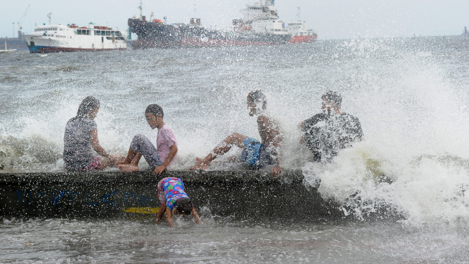 Residents along Manila Bay play in the waves created by nearby Typhoon Noul on May 10, 2015 as it approaches the northern Philippines. More than 2,000 people were fleeing their homes as Typhoon Noul approached the northern Philippines on May 10, triggering warnings of possible flash floods, landslides and tsunami-like storm surges.   AFP PHOTO / Jay DIRECTO        (Photo credit should read JAY DIRECTO/AFP/Getty Images)