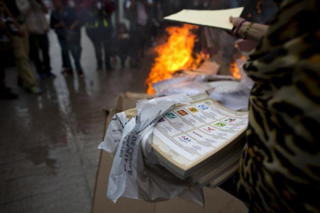 Ciudadanos encabezados por padres de los estudiantes desaparecidos de Ayotzinapa queman boletas electorales en Tixtla, Guerrero, domingo 7 de junio de 2015. Otros vecinos del lugar resistieron la quema en el da de elecciones legislativas, a gobernadores y cargos locales. (AP Foto/Rebecca Blackwell)