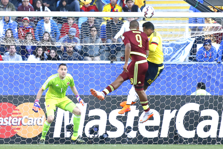 Venezuela's Jose Rondon, center, heads the ball to score as Colombia's Jeison Murillo, right, fails to defend and Colombia's goalkeeper David Ospina, left, looks on during a Copa America Group C soccer match at El Teniente stadium in Rancagua, Chile, Sunday, June 14, 2015. (AP Photo/Luis Hidalgo)