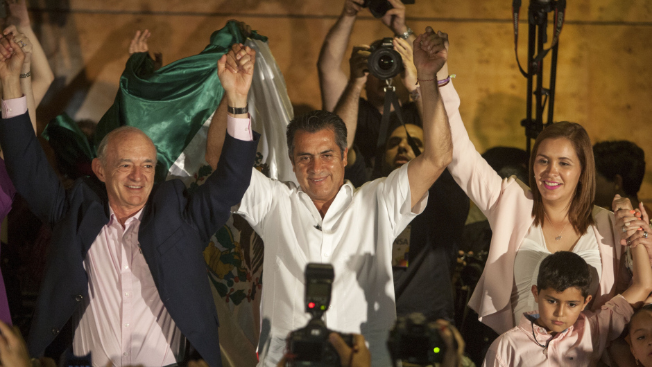 Jaime Rodriguez Calderon (C), running for governor in the industrial northern state of Nuevo Leon, holds up his hands as he celebrates in Monterrey Nuevo Leon, Mexico on June 7, 2015. Exit polls showed Jaime Rodriguez Calderon, a foul-mouthed rancher dubbed "El Bronco," will become the first independent candidate to be elected governor since a 2014 electoral reform,  riding a wave of discontent against corrupt politicians. AFP PHOTO/ Julio Cesar Aguilar        (Photo credit should read Julio Cesar Aguilar/AFP/Getty Images)