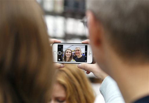 El director general de Apple Tim Cook se toma una foto con una empleada de Apple durante un evento por el lanzamiento del iPhone 6 en una tienda de la marca en Palo Alto, California, el 19 de septiembre de 2014. (Foto AP/Tony Avelar, File)