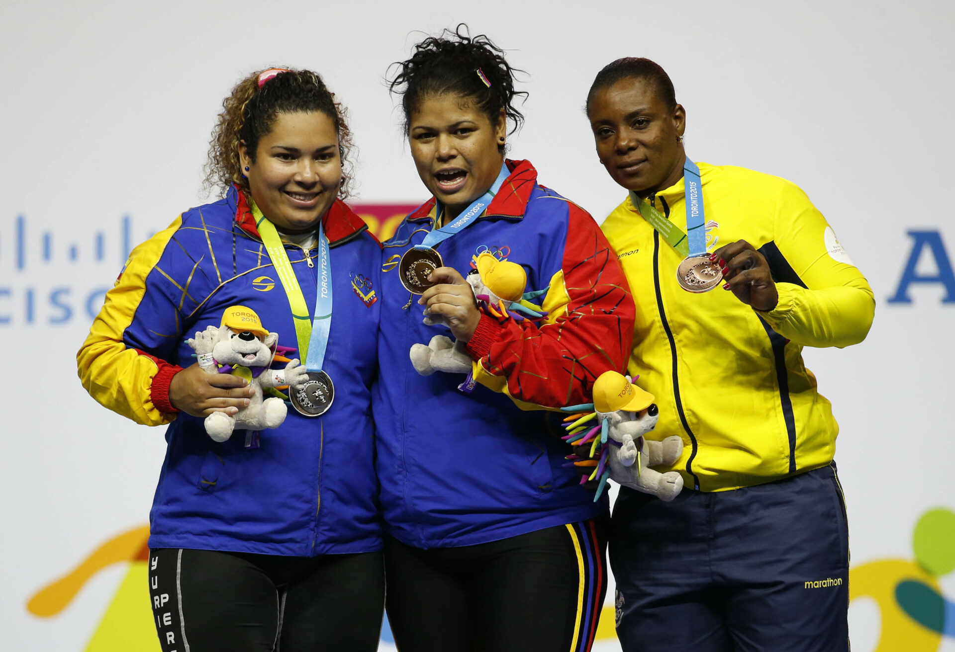 Jul 15, 2015; Toronto, Ontario, CAN; Naryury Perez Reveron of Venezuela (left) and Yaniuska Espinosa of Venezuela (middle) and Seledina Nieve Arroyo of Ecuador (right) celebrate on the podium after the women's +75kg weightlifting competition during the 2015 Pan Am Games at Oshawa Sports Centre. Mandatory Credit: Jeff Swinger-USA TODAY Sports