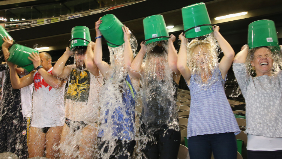 MELBOURNE, AUSTRALIA - AUGUST 22:  Participants tip buckets of ice water over their heads as they take part in the World Record Ice Bucket Challenge at Etihad Stadium on August 22, 2014 in Melbourne, Australia. Over 700 people took part in setting the new world record. The Ice Bucket Challenge is the social media phenomenon which is helping raise awareness and money for sufferers of Motor Neurone Disease.  (Photo by Scott Barbour/Getty Images)