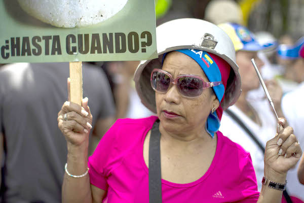CAR07. CARACAS (VENEZUELA), 08/03/2014.- Una mujer participa en una protesta con ollas vacÌas contra el gobierno del presidente venezolano, Nicol·s Maduro, hoy, s·bado 8 de marzo de 2014, en una calle en Caracas (Venezuela). El lÌder de la oposiciÛn venezolana Henrique Capriles convocÛ hoy a una marcha en Caracas para protestar por la escasez de productos b·sicos en el paÌs, en una nueva jornada de manifestaciones contra el Gobierno.EFE/MIGUEL GUTIERREZ