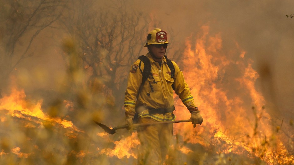 LOWER LAKE, CA - JULY 31:  Cal Fire firefighter Johnny Miller monitors flames from the Rocky Fire as it approaches a home on July 31, 2015 in Lower Lake, California. Over 900 firefighters are battling the Rocky Fire that erupted to over 15,000 acres since it started on Wednesday afternoon. The fire is currently five percent contained and has destroyed 3 homes.  (Photo by Justin Sullivan/Getty Images)