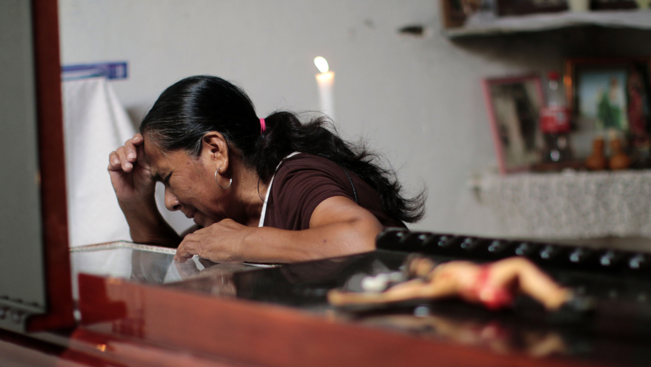 A woman attends the wake of vigilante group leader Miguel Angel Jimenez Blanco in Xaltianguis, Guerrero State, Mexico, on August 9, 2015. The corpse of Jimenez, who was set about the task of searching the 43 students who went missing past September, was found in a taxi Saturday in Guerrero state.   AFP PHOTO / Pedro PARDO        (Photo credit should read Pedro PARDO/AFP/Getty Images)