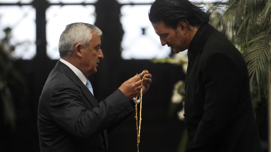 Guatemala's singer Ricardo Arjona (R) is decorated with the "Orden del Quetzal" by Guatemalan President Otto Perez Molina at the Culture Palace in Guatemala City on March 21, 2013. AFP PHOTO Johan ORDONEZ        (Photo credit should read JOHAN ORDONEZ/AFP/Getty Images)
