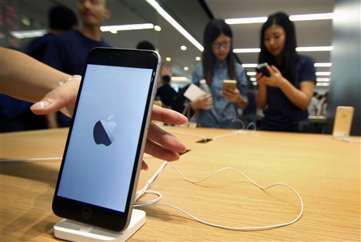 Unas mujeres ven iPhones en la nueva Apple Store en Nanjing, China, el 19 de septiembre de 2015. (Chinatopix via AP)