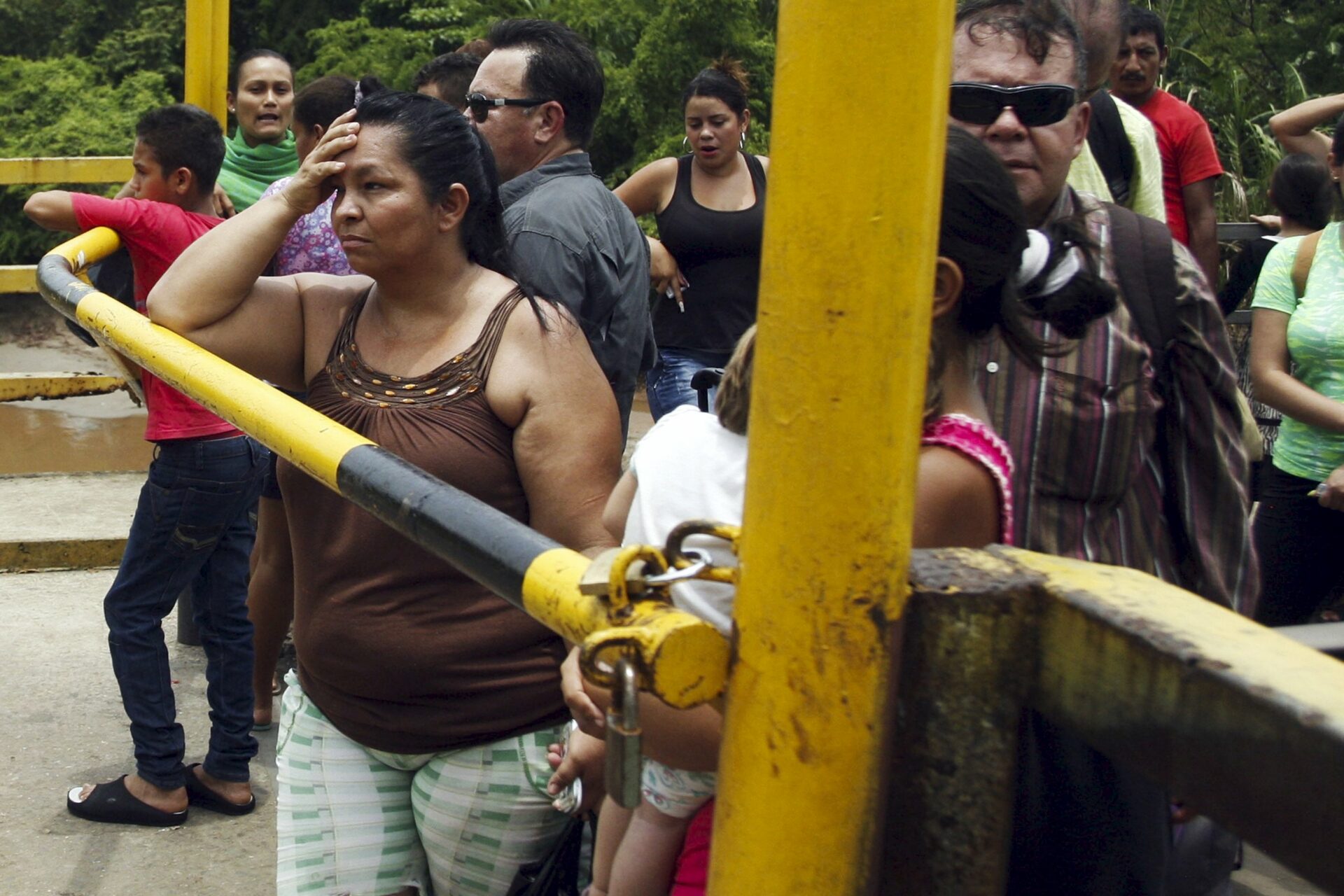 People stand next to a closed gate as they wait to try to cross La Union international bridge, on the border with Colombia at Boca de Grita in Tachira state, Venezuela August 29, 2015. Venezuela and Colombia each recalled their ambassadors to the other country on Thursday, amid a diplomatic crisis sparked when socialist-run Venezuela closed two border crossings and deported over a thousand Colombians. Venezuelan President Nicolas Maduro shut the crossings last week after a shootout between smugglers and troops wounded three soldiers. He later extended the closing indefinitely and has characterized the deportations as a crackdown on paramilitary gangs. REUTERS/Carlos Eduardo Ramirez