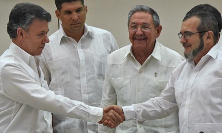 El presidente colombiano Juan Manuel Santos y el jefe de la guerrilla comunista de las FARC, Timoleón Jiménez, alias “Timochenko”, estrellan sus manos a instancia del presidente de Cuba, Raúl Castro Ruz.
AFP /9 LUIS ACOSTA