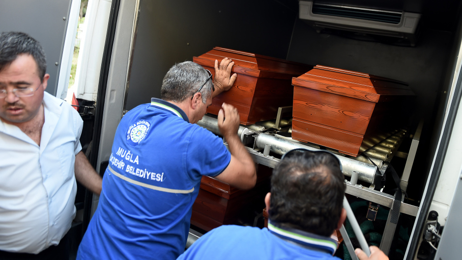 Men load onto a funeral vehicle the coffins of migrants and three-year old Aylan Kurdi, a Syrian boy whose body was washed up on a Turkish beach after a boat carrying refugees sank as it crossed to the Greek island of Kos, at the morgue in Mugla, southern Turkey, on September 3, 2015. The father of a three-year-old Syrian boy whose body was  washed up on a Turkish beach, an image that shocked the world, said on September 3 his children "slipped through my hands" as their boat was taking in water en route to Greece. Abdullah, whose surname is given by Turkish media as Kurdi but sources in Syria say is actually called Shenu, lost his three-year-old son Aylan, four-year-old son Ghaleb and wife Rihana in the tragedy. AFP PHOTO / OZAN KOSE        (Photo credit should read OZAN KOSE/AFP/Getty Images)
