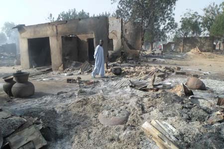 Un hombre camina entre viviendas quemadas luego de un ataque de extremistas de Boko Haram en al pueblo de Dalori, a 5 kilómetros (3 millas) de Maiduguri, Nigeria, el domingo 31 de enero de 2016.
AP / JOSSY OLA