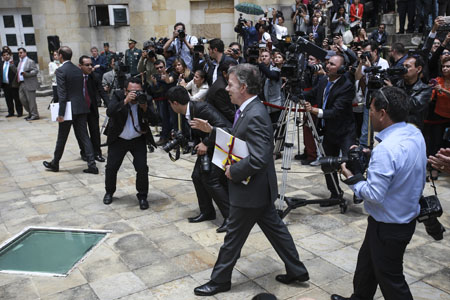 Sin escoltas, rodeado de periodistas y camarógrafos, el presidente Santos cuando ingresaba al Congreso en Bogotá, a comunicar el fin del conflicto armado con la guerrilla de las FARC.
IVAN VALENCIA / AFP