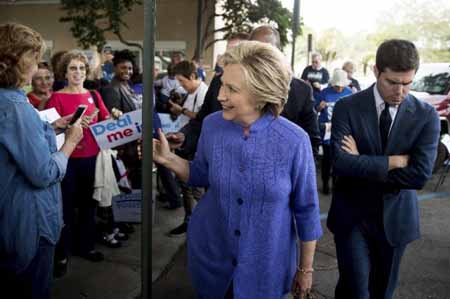 Hillary Clinton saluda a partidarios durante una parada en Pompano Beach, Florida, el 30 de octubre del 2016. La acompaña pensativo su secretario de prensa Nick Merrill.ANDREW HARNIK / AP
