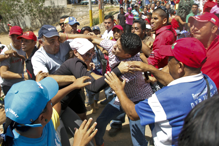En el único incidente de la jornada, seguidores del gobierno se enfrentaron a golpes y empujones a opositores en la entrada de la comunidad Villa Rosa, en Margarita, cuyos vecinos sonaron cacerolas al mandatario hace un mes.AFP