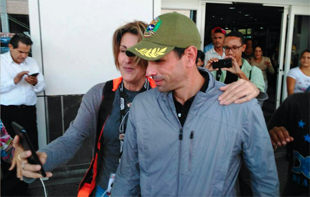 En medio de su molestia por la anulación de su pasaporte, en un pasillo del aeropuerto Simón Bolívar, Capriles posó para un selfie con una seguidora.SRT / AFP