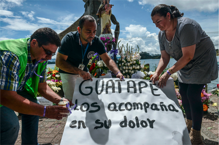 En un homenaje a las víctimas, los vecinos de Guatapé colocaron rosas y margaritas al pie de la estatua "La sembradora de sueños", símbolo de la esperanza en el malecón de la represa.JOAQUIN SARMIENTO / AFP