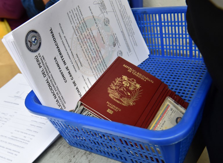 View of Venezuelan migrants documents at an Interpol facility in Lima on August 29, 2018. Peru allowed the entry of hundreds of Venezuelan citizens as cooperation agreements between Colombia and Peru are drawn to filter migrants with criminal records, and health authorities at the Ecuador-Peru border evaluate how to deal with vast numbers of migrants not bearing health records. / AFP PHOTO / CRIS BOURONCLE