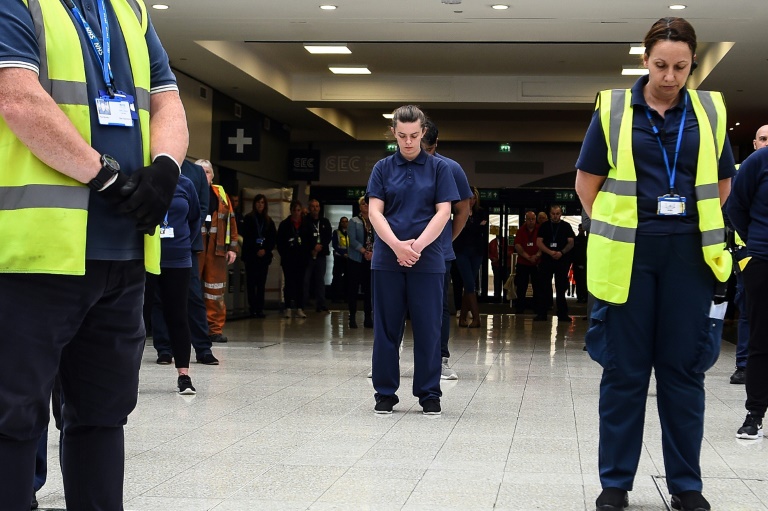 Unos trabajadores del Servicio Nacional de Salud británico guardan un minuto de silencio en memoria de los trabajadores no esenciales fallecidos de coronavirus este martes 28 de abril de 2020 en el Hospital Louisa Jordan de Glasgow