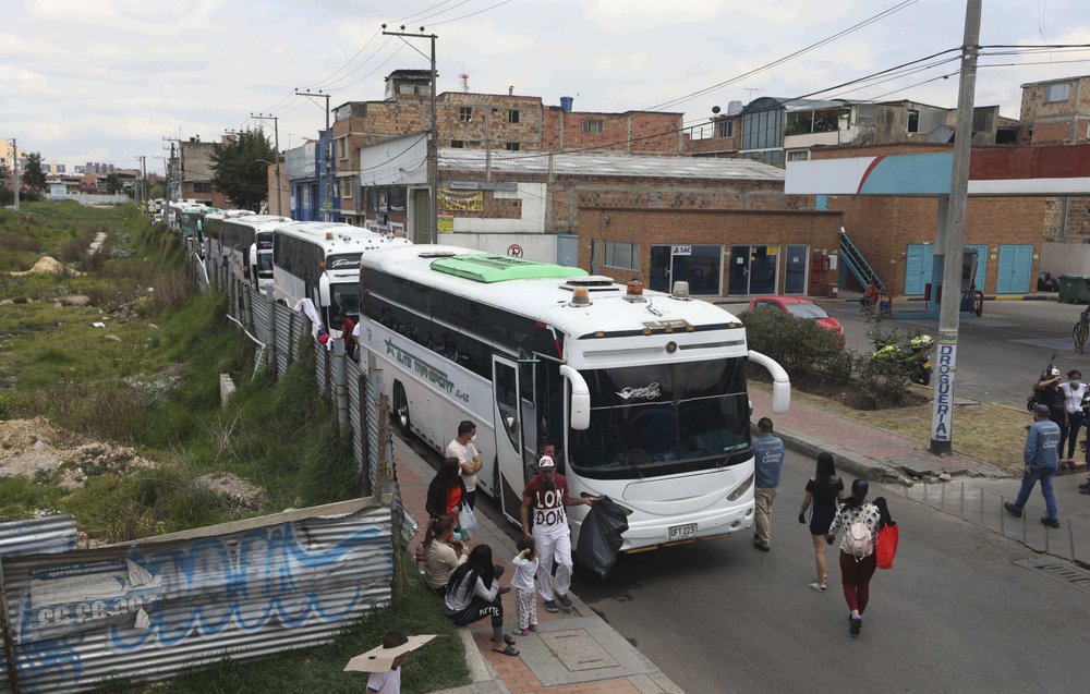 Migrantes venezolanos suben a autobuses con destino a la frontera venezolana, en medio de la pandemia del coronavirus, en Bogotá, Colombia