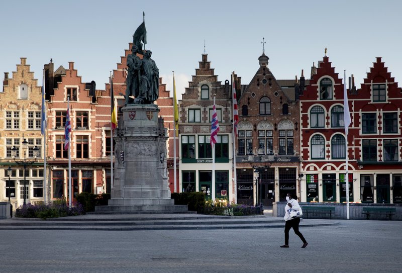 Una mujer con mascarilla cruza la Plaza del Mercado en Brujas, Bélgica, este miércoles 13 de mayo de 2020
