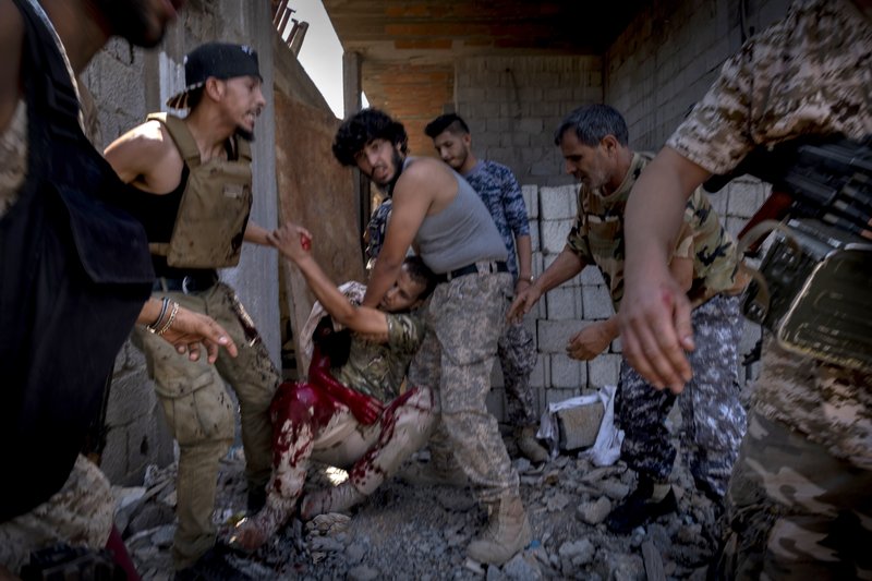 Un combatiente de la unidad Shelba, aliada con el gobierno libio que tiene el apoyo de Naciones Unidas, es auxiliado por sus compañeros después de ser herido de muerte en el vecindario Salah-addin