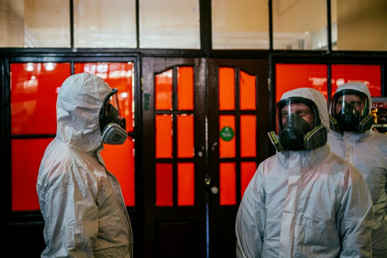 Empleados del Ministerio de Emergencias ruso con indumentaria protectora llegan a la estación de tren de Kazansky para desinfectarla, el 28 de mayo de 2020 en Moscú