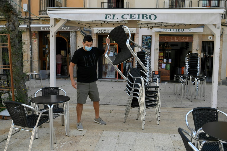 Un camarero prepara la terraza de un local de hostelería de la ciudad española de Tarragona el 11 de mayo de 2020
