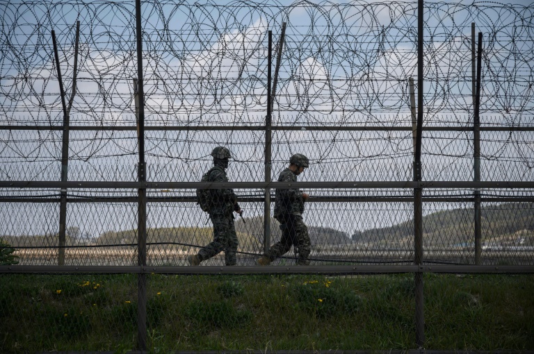 Soldados surcoreanos patrullan junto a una valla de alambre de espino en la zona desmilitarizada que divide las dos coreas