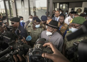 El ex presidente de Nigeria Goodluck Jonathan (centro) habla a la prensa en el aeropuerto de Bamako en Mali, como parte de su misión de diálogo