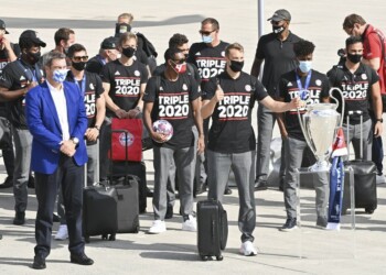 El gobernador de Bavaria Markus Soeder (izquierda) junto al plantel del Bayern Múnich tras su arribo al aeropuerto de Múnich, Alemania, este lunes 24 de agosto de 2020. El arquero Manuel Neuer carga el trofeo de la Liga de Campeones