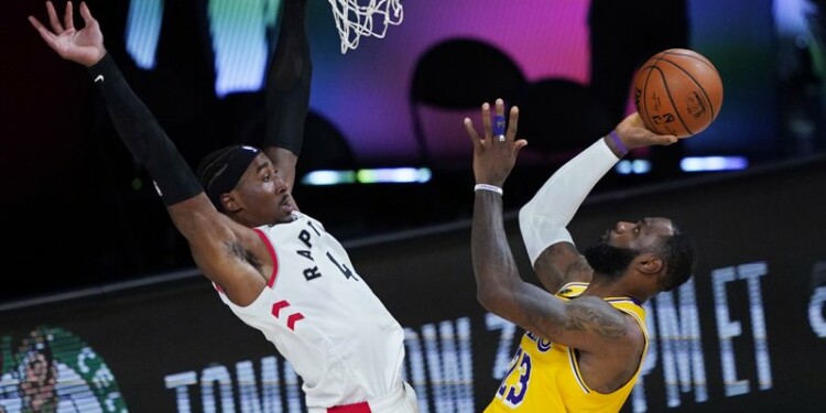 LeBron James (23), de los Lakers de Los Ángeles, dispara al aro frente a Rondae Hollis-Jefferson (4) de los Raptors de Toronto