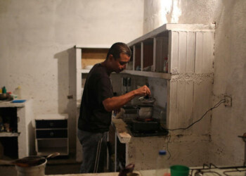 Juan Meza prepara café en un casa en Güigüe antes de salir a buscar el sustento de su familia